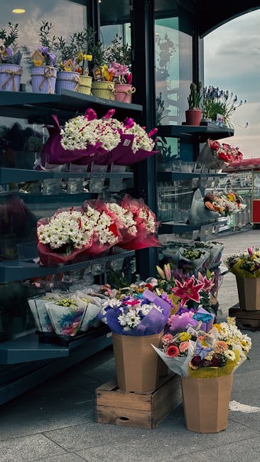 A display of various floral arrangements and bouquets at flowersmottingham.co.uk, featuring vibrant white, pink, purple, and yellow flowers wrapped in colorful paper and tied with ribbons. The arrange